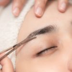 Eyebrows trimming service in spa salon, Face hair cutting and trim with small scissor tool for face